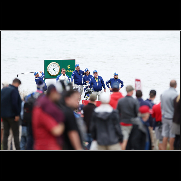 KOHLER, WISCONSIN - SEPTEMBER 21: Shane Lowry of Ireland and team Europe plays his shot from the 18th tee as vice-captain Graeme McDowell of Northern Ireland and team Europe, Ian Finnis, Tommy Fleetwood of England and team Europe, Mick Donaghy, and Tyrrell Hatton of England and team Europe look on during a practice round prior to the 43rd Ryder Cup at Whistling Straits on September 21, 2021 in Kohler, Wisconsin. (Photo by Richard Heathcote/Getty Images)